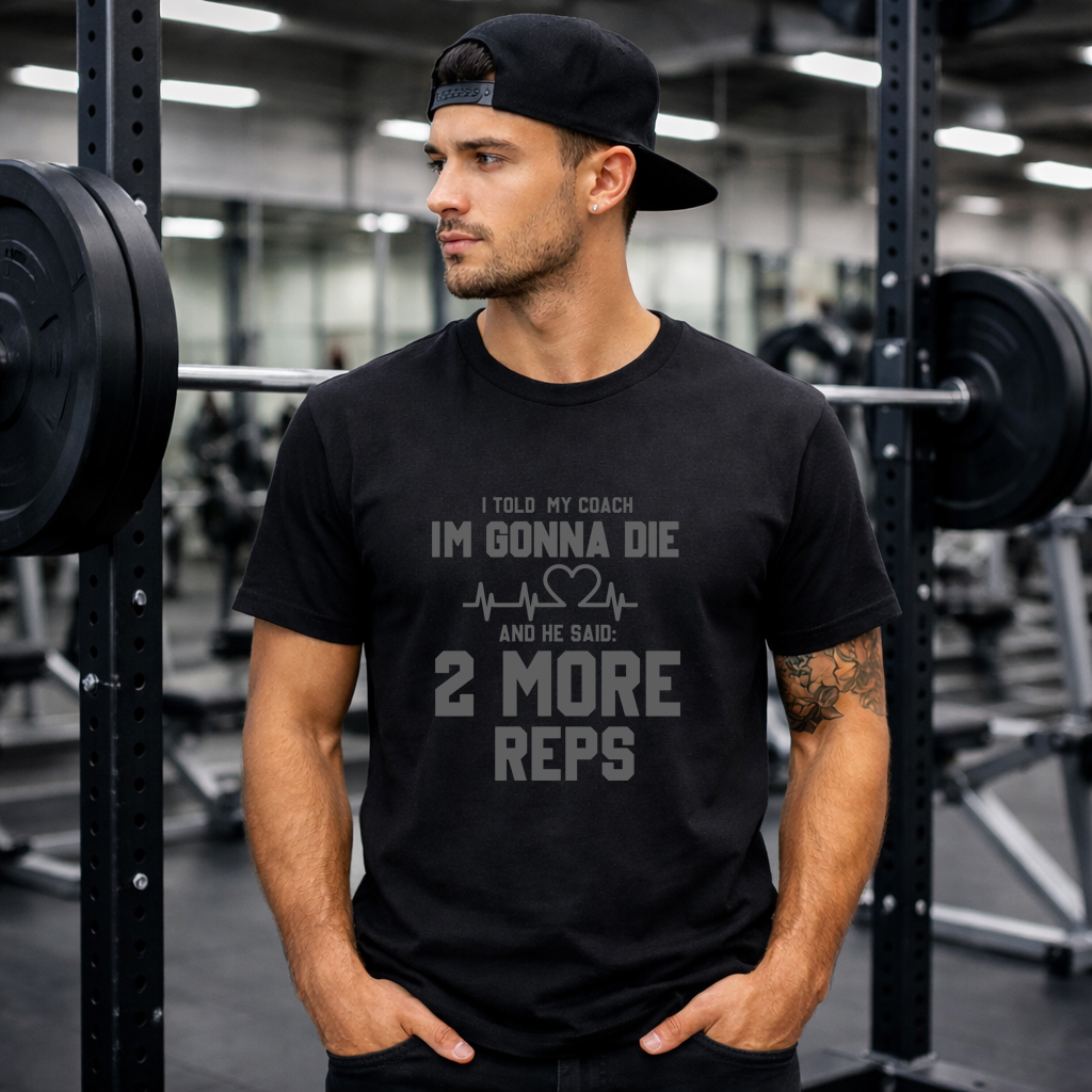 Funny Gym Workout Tee 2 More Reps Edition 2026 2 Male model wearing black funny workout t-shirt in gym setting, I'm Gonna Die 2 More Reps design front view